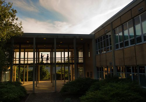 Phillips Hall with two people talking on breezeway